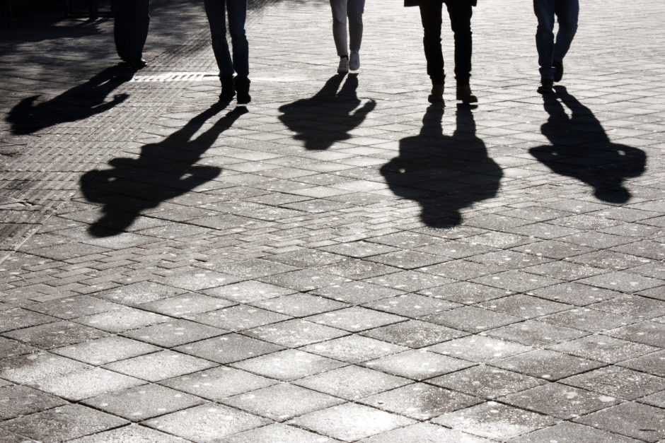 Legs and shadows of people walking.